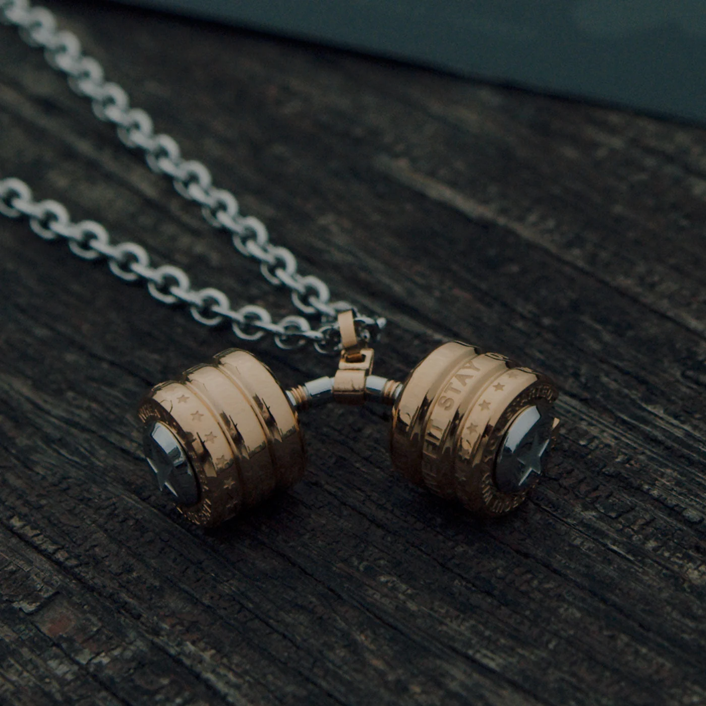 RAWNESS dumbbell necklace on dark wood